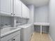 Bright laundry room features white cabinets, a utility sink, and modern washer and dryer appliances at 1104 Gaston Manor Dr, Durham, NC 27703
