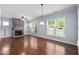 Living room featuring hardwood floors and a stone fireplace with built-in shelving at 1104 Gaston Manor Dr, Durham, NC 27703