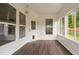 Sunroom showcasing windows, vinyl siding, wood-look flooring, and door with pet door at 1104 Gaston Manor Dr, Durham, NC 27703