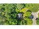 Aerial view of a home with a dark roof surrounded by lush greenery and mature trees at 113 Fox Run, Henderson, NC 27536