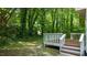 Exterior view of home's deck and backyard with many trees at 113 Fox Run, Henderson, NC 27536
