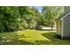 Expansive grassy backyard with mature trees offering shade, perfect for outdoor activities at 113 Fox Run, Henderson, NC 27536