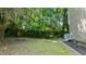 Spacious backyard area featuring a brick firepit, grassy space, and some wooded surroundings at 113 Fox Run, Henderson, NC 27536