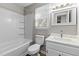 Bright bathroom featuring a white vanity, marble countertop and tub with shower at 113 Fox Run, Henderson, NC 27536