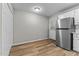 Open kitchen area with stainless steel refrigerator, white cabinets, and outdoor access at 113 Fox Run, Henderson, NC 27536