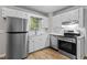 Well-maintained kitchen equipped with stainless steel appliances, white cabinets, and a bright window at 113 Fox Run, Henderson, NC 27536