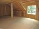 An open attic with a wooden frame and a large window, ready to be turned into living space at 1155 Shonele Ln, Stem, NC 27581