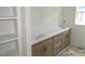 Bathroom featuring dual sinks with wood cabinets, white stone countertops and a large mirror at 1155 Shonele Ln, Stem, NC 27581