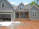 Charming home featuring gray siding, a front porch, an attached garage, and brick accents at 1155 Shonele Ln, Stem, NC 27581