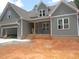 Charming new construction home featuring gray siding, brick accents, and an attached two-car garage at 1155 Shonele Ln, Stem, NC 27581