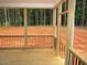 Covered porch with wooden railing and flooring, offering a relaxing outdoor space at 1155 Shonele Ln, Stem, NC 27581