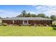 Backyard view of a brick home with a well-manicured lawn and landscaping at 12082 Nc 42, Fuquay Varina, NC 27526