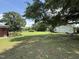 Spacious backyard with mature trees, an outbuilding, and a serene green lawn at 12082 Nc 42, Fuquay Varina, NC 27526