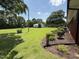 Green backyard featuring mature trees, landscaping, and a glimpse of a white outbuilding at 12082 Nc 42, Fuquay Varina, NC 27526