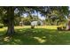 Spacious backyard featuring a large tree, playset, lush lawn and metal outbuilding at 12082 Nc 42, Fuquay Varina, NC 27526