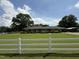 Ranch home showcasing a well-manicured lawn bordered by a white picket fence and mature trees at 12082 Nc 42, Fuquay Varina, NC 27526