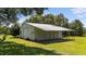 A metal outbuilding with a roll-up door sits on a lush green lawn at 12082 Nc 42, Fuquay Varina, NC 27526
