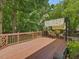 Inviting back deck featuring a shaded pergola, perfect for outdoor entertaining surrounded by lush greenery at 128 Castlewood Dr, Cary, NC 27511