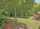 A lush backyard features a wooden deck, mature trees, and a charming garden archway at 128 Castlewood Dr, Cary, NC 27511