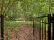 View of the backyard gate leading to the wooded area at 128 Castlewood Dr, Cary, NC 27511