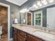 Well-lit bathroom featuring a dual sink vanity with wood cabinets and a large mirror with decorative lighting at 128 Castlewood Dr, Cary, NC 27511