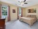 Bedroom features carpet flooring, ceiling fan, and two windows at 128 Castlewood Dr, Cary, NC 27511