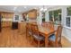 Open dining room with wood floors, a window with tree views, and access to the kitchen at 128 Castlewood Dr, Cary, NC 27511