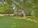 Two-story brick and siding home with a lush front lawn and mature shade trees at 128 Castlewood Dr, Cary, NC 27511