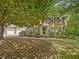 Traditional brick home with a three-car garage, mature trees, and well-maintained landscaping at 128 Castlewood Dr, Cary, NC 27511