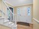 Bright foyer featuring hardwood floors, staircase, and door with stained glass sidelights at 128 Castlewood Dr, Cary, NC 27511