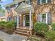 Inviting front entrance with a covered porch, brick steps, and classic black door at 128 Castlewood Dr, Cary, NC 27511