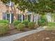 Close-up of the brick home's charming front porch with a covered entryway and manicured bushes at 128 Castlewood Dr, Cary, NC 27511