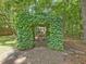 Ivy-covered garden archway with a stone path and wooded surroundings at 128 Castlewood Dr, Cary, NC 27511