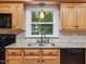 Close-up of stainless steel sink and appliances, wood cabinets and a view to the backyard at 128 Castlewood Dr, Cary, NC 27511
