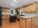 Well-lit kitchen featuring wooden cabinets, granite countertops, an island, and modern appliances at 128 Castlewood Dr, Cary, NC 27511