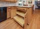 Open island cabinet access in the kitchen with storage shelves and black hardware at 128 Castlewood Dr, Cary, NC 27511