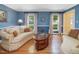 Sunlit living room featuring hardwood floors, neutral sofas, and large windows with nature views at 128 Castlewood Dr, Cary, NC 27511