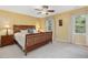 Bright main bedroom featuring soft carpeting and a ceiling fan adding a touch of charm and comfort at 128 Castlewood Dr, Cary, NC 27511