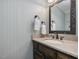 Stylish powder room with a decorative mirror, elegant vanity, and modern fixtures at 128 Castlewood Dr, Cary, NC 27511