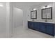 Modern bathroom with a double sink vanity featuring a white countertop, dark blue cabinets, and a tiled shower at 1319 Richfield Oaks Dr, Fuquay Varina, NC 27526