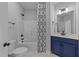 Well-lit bathroom featuring a tub, shower, toilet, and vanity with a navy blue cabinet at 1319 Richfield Oaks Dr, Fuquay Varina, NC 27526