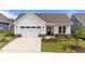 Charming single-story home featuring a white exterior, attached garage, and professionally landscaped front yard at 1319 Richfield Oaks Dr, Fuquay Varina, NC 27526