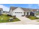 Inviting exterior featuring a manicured lawn, white siding, and an attached garage with lush plantings at 1319 Richfield Oaks Dr, Fuquay Varina, NC 27526