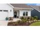 Detailed view of the home's entrance, showcasing brick accents, lush landscaping, and a black front door at 1319 Richfield Oaks Dr, Fuquay Varina, NC 27526