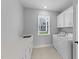 Well-lit laundry room features a window, white cabinetry and a washer and dryer at 1319 Richfield Oaks Dr, Fuquay Varina, NC 27526
