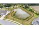 A community pond surrounded by a black fence is lined with bushes and small trees at 1319 Richfield Oaks Dr, Fuquay Varina, NC 27526