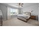 Elegant bedroom with a large window, stylish furniture, and white wall paneling at 140 Big Barn Dr, Wendell, NC 27591