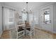 This dining room has a wood table, white chairs, an elegant light fixture, and great natural light from the windows at 140 Big Barn Dr, Wendell, NC 27591