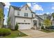 Charming two-story home with white siding, an attached garage, and a beautifully landscaped front yard at 140 Big Barn Dr, Wendell, NC 27591