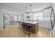 Bright kitchen featuring white cabinets, stainless appliances, a large island, and pendant lighting at 140 Big Barn Dr, Wendell, NC 27591